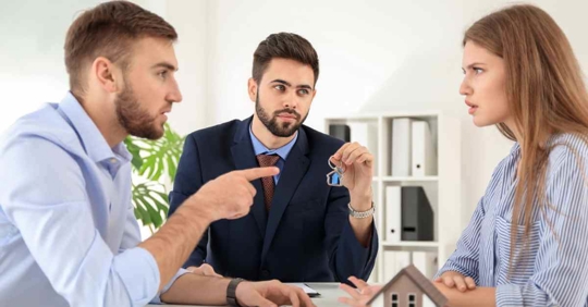 A man and woman arguing with each other while a male attorney holds a set of keys in between them