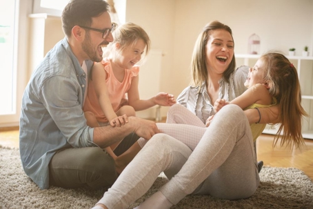 Mom and dad laughing with two daughters