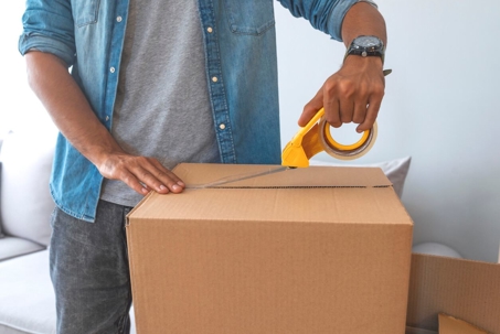 Man taping up moving boxes