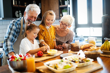 Grandparents cooking in kitchen with grandchildren practicing their NC grandparents rights