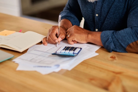 Person using calculator to fill out documents