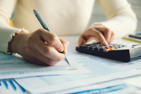 Woman with calculator and bills