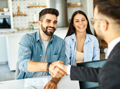 happy couple shaking hands with lawyer